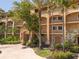 Condo exterior featuring a circular drive, manicured landscaping, and covered parking at 93 Vivante Blvd # 9344, Punta Gorda, FL 33950