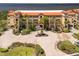 Beautiful waterfront condo building with lush landscaping and a circular brick paved driveway at 93 Vivante Blvd # 9344, Punta Gorda, FL 33950