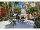 Outdoor stone fireplace with seating creates an inviting ambiance, surrounded by lush greenery near waterfront at 93 Vivante Blvd # 9344, Punta Gorda, FL 33950