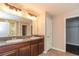 Bathroom with dual sinks, granite countertops, and a walk-in shower at 10204 Carloway Hills Dr, Wimauma, FL 33598