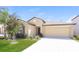Well-maintained, single-story home with a two-car garage, manicured lawn, and fresh landscaping at 10204 Carloway Hills Dr, Wimauma, FL 33598