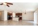Bright, open-concept space with tile floors, ceiling fan, and a kitchen island with seating at 10204 Carloway Hills Dr, Wimauma, FL 33598