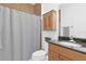 Clean bathroom featuring a granite countertop, wooden cabinetry and tub with shower at 12857 Pinnacle Ln, Venice, FL 34293