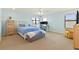 Bright bedroom featuring a queen-sized bed, desk, yellow arm chair, and two windows at 12857 Pinnacle Ln, Venice, FL 34293