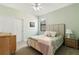A cozy bedroom with a queen-size bed, a nightstand, and a double-door closet at 12857 Pinnacle Ln, Venice, FL 34293