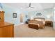 Relaxing bedroom with a wooden bed frame, neutral colors, and a ceiling fan at 12857 Pinnacle Ln, Venice, FL 34293