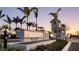 Solstice Wellen Park entrance sign surrounded by landscaping and palm trees beneath a colorful sunset sky at 12857 Pinnacle Ln, Venice, FL 34293