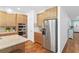 Spacious kitchen area showcasing wooden cabinetry, a stainless steel refrigerator, and modern appliances at 12857 Pinnacle Ln, Venice, FL 34293