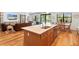 Kitchen with island that flows to the dining and living area showcasing the open-concept design with hardwood floors throughout at 12857 Pinnacle Ln, Venice, FL 34293