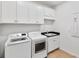 Bright laundry room with white cabinets and newer model washing machine and dryer at 12857 Pinnacle Ln, Venice, FL 34293