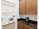 Open laundry room featuring granite countertop cabinets and newer model appliances at 12857 Pinnacle Ln, Venice, FL 34293