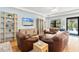 Living room with leather furniture, hardwood floors, a large window, and a TV mounted on the wall at 12857 Pinnacle Ln, Venice, FL 34293