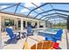 Outdoor oasis featuring a screened pool, hot tub, and colorful seating options for relaxation and entertainment at 12857 Pinnacle Ln, Venice, FL 34293