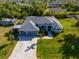 Stunning aerial view of a beautifully landscaped home with a paver driveway at 13443 Boabadilla Ln, Port Charlotte, FL 33981
