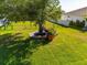 Spacious backyard featuring a large tree, wooden deck, and lush green lawn at 13443 Boabadilla Ln, Port Charlotte, FL 33981