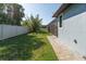 Spacious, fenced backyard provides privacy with lush grass and a stone pathway to the screened patio at 13443 Boabadilla Ln, Port Charlotte, FL 33981