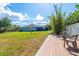 A generous backyard includes a wooden deck, swing set and partial view of a screened in pool at 13443 Boabadilla Ln, Port Charlotte, FL 33981