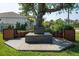 A charming backyard haven features a custom wooden bench under a sprawling shade tree at 13443 Boabadilla Ln, Port Charlotte, FL 33981