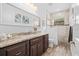 Bathroom boasts a granite vanity with a full mirror and shower with decorative tile at 13443 Boabadilla Ln, Port Charlotte, FL 33981