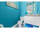 Charming powder room with stylish fixtures, bright blue walls, and beach-themed decor at 13443 Boabadilla Ln, Port Charlotte, FL 33981