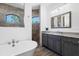 Bathroom features dual vanities, a walk-in shower, and a standalone tub at 13443 Boabadilla Ln, Port Charlotte, FL 33981