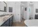 Bathroom features a gray vanity with granite counters, a soaking tub, and open doorway to the toilet at 13443 Boabadilla Ln, Port Charlotte, FL 33981