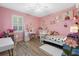 Bedroom with pink walls, wood floors, a ceiling fan, a window, and a full-sized bed at 13443 Boabadilla Ln, Port Charlotte, FL 33981