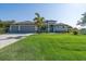 Beautiful, well-manicured lawn and a lovely two-story home with a three-car garage and custom front door at 13443 Boabadilla Ln, Port Charlotte, FL 33981