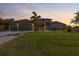 This elegant, well-manicured lawn and a lovely two-story home with a three-car garage at sunset at 13443 Boabadilla Ln, Port Charlotte, FL 33981