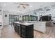 Spacious kitchen features a large island with black cabinets and a wine cooler at 13443 Boabadilla Ln, Port Charlotte, FL 33981