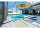 Gorgeous screened-in pool area for outdoor relaxation with an umbrella and patio seating at 13443 Boabadilla Ln, Port Charlotte, FL 33981