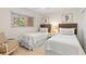 Bright bedroom with twin beds, beach-themed decor, and natural light from the window at 1345 Mediterranean Dr # A105, Punta Gorda, FL 33950