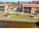 Waterfront condo community with manicured lawn, community pool, and canal access at 1345 Mediterranean Dr # A105, Punta Gorda, FL 33950