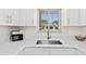Well-lit kitchen with a stainless steel sink, white countertops, and white cabinetry at 1345 Mediterranean Dr # A105, Punta Gorda, FL 33950