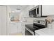 Modern kitchen featuring white cabinets, stainless steel microwave, and sleek countertops at 1345 Mediterranean Dr # A105, Punta Gorda, FL 33950