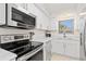 Updated kitchen boasts stainless steel appliances, white cabinets, and modern countertops at 1345 Mediterranean Dr # A105, Punta Gorda, FL 33950