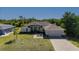 Aerial view of tan single story home with lush yard and beautiful brick paver driveway and walkway at 1606 Navigator Rd, Punta Gorda, FL 33983