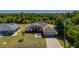 High angle aerial view of tan single story home with manicured yard and brick paver driveway at 1606 Navigator Rd, Punta Gorda, FL 33983