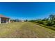 Expansive grassy yard, rear exterior, and covered lanais with outdoor seating in a desirable community at 1606 Navigator Rd, Punta Gorda, FL 33983