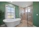 Spa bathroom featuring a soaking tub and walk-in shower with tile surround, and an abundance of light at 1606 Navigator Rd, Punta Gorda, FL 33983