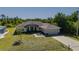 Aerial front exterior showcasing charming tan single story home with attached garage and decorative fountain at 1606 Navigator Rd, Punta Gorda, FL 33983