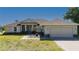 Charming single-story home featuring a landscaped front yard, a two-car garage, and a covered entryway with double doors at 1606 Navigator Rd, Punta Gorda, FL 33983