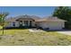 Charming tan single story home with attached garage, manicured landscaping, and decorative fountain at 1606 Navigator Rd, Punta Gorda, FL 33983