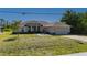 Charming tan single story home with attached garage, manicured landscaping, and decorative fountain at 1606 Navigator Rd, Punta Gorda, FL 33983