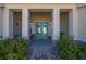 Inviting front porch with double doors, decorated with wreaths, and a cozy seating area at 1606 Navigator Rd, Punta Gorda, FL 33983