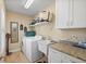 Functional laundry room with modern washer, dryer, sink, and ample counter space at 1606 Navigator Rd, Punta Gorda, FL 33983