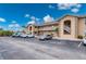 Condo building showing parking area, tan paint, stairs to the second story and manicured landscaping at 175 Kings Hwy # B2 1522, Punta Gorda, FL 33983