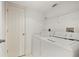 Bright laundry room features a stacked washer and dryer with a wire shelf for organized storage solutions at 175 Kings Hwy # B2 1522, Punta Gorda, FL 33983