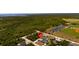 Aerial view of the community and home with a red marker, surrounded by lush greenery at 2229 Wakefield St, Port Charlotte, FL 33948