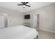The bedroom features neutral paint, tile flooring, a ceiling fan, and a mounted TV at 2229 Wakefield St, Port Charlotte, FL 33948